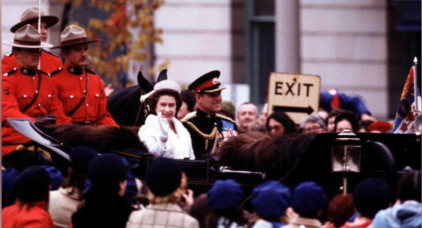 Queen Elizabeth II and Prince Philip wave to crowds as they ride in a carriage to Parliament Hill in Ottawa on Oct. 18, 1977